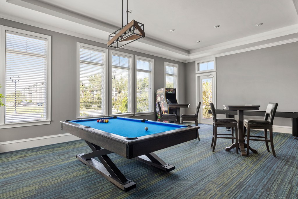 A pool table in a room with a chair and a dining table.