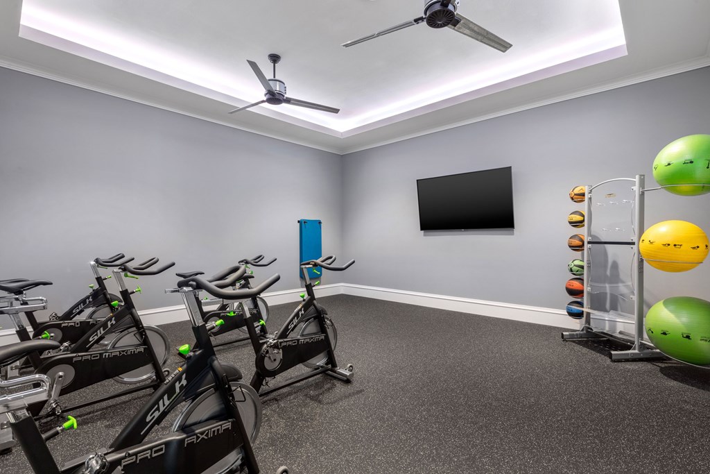 A room with exercise bikes and a fan.