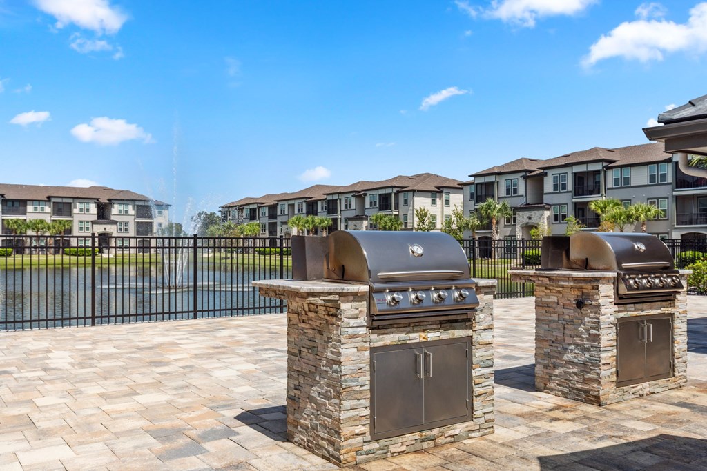 Two stone BBQs in front of apartment buildings.