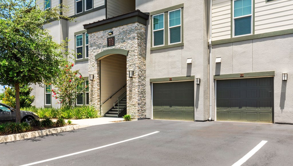 A modern two-story house with a stone archway entrance and two garage doors.