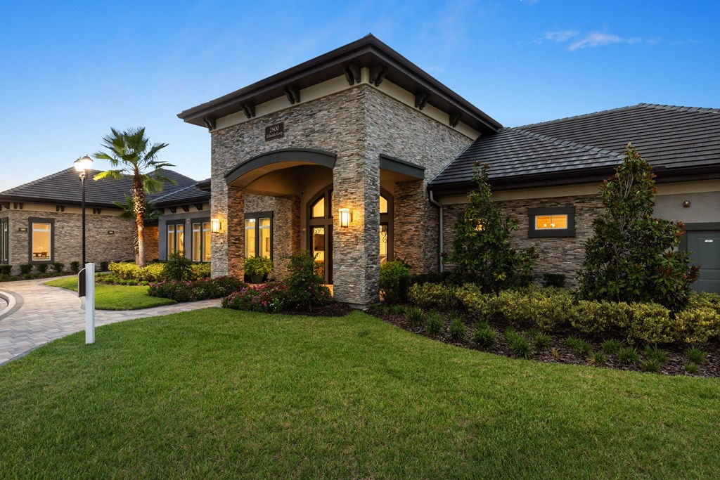 A house with a stone facade and a palm tree in front.