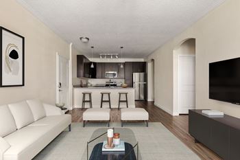 A modern living room with a white sofa, a glass coffee table, and a flat-screen TV.