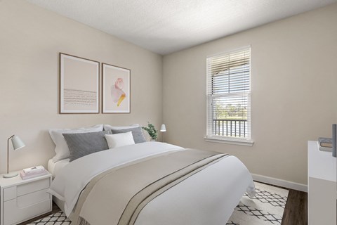 A bedroom with a large bed and a window with blinds.