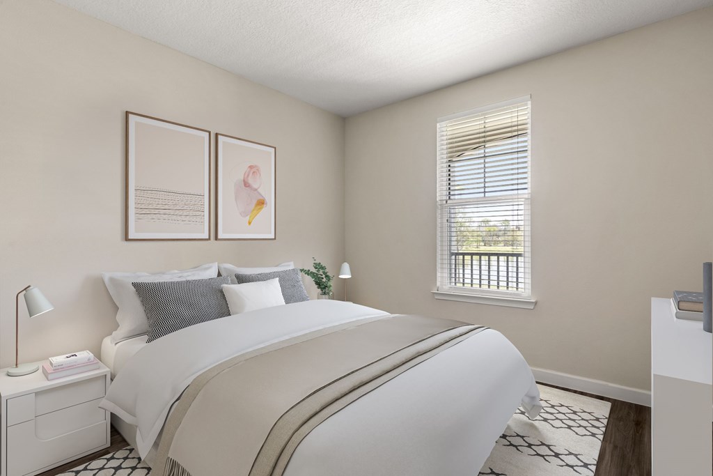 A bedroom with a large bed and a window with blinds.