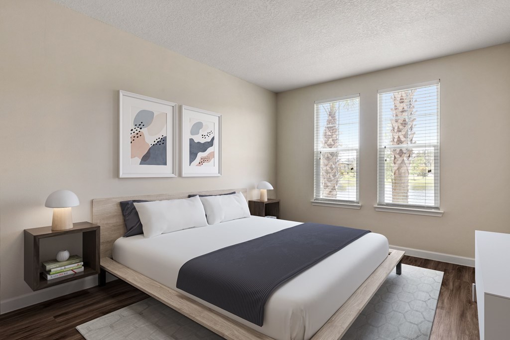 A bedroom with a large bed and two lamps on side tables.