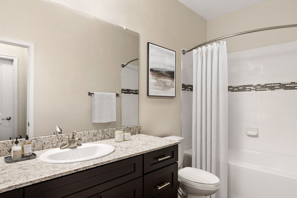 A bathroom with a white toilet and a white shower curtain.