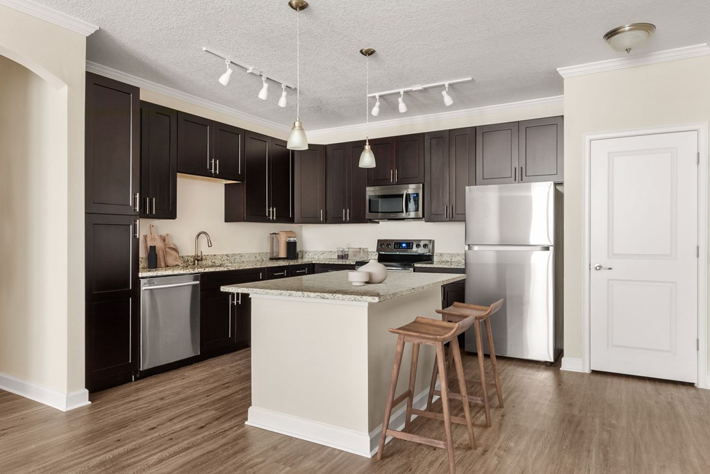 A kitchen with a white island and a white refrigerator.
