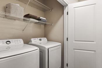 A white washing machine and dryer in a small laundry room.