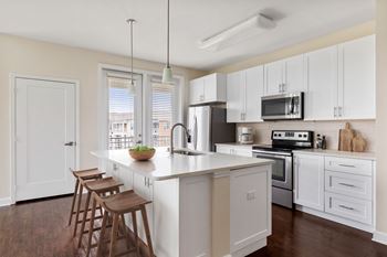 A kitchen with white cabinets and a wooden island.