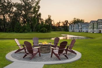 A fire pit surrounded by chairs in a backyard.