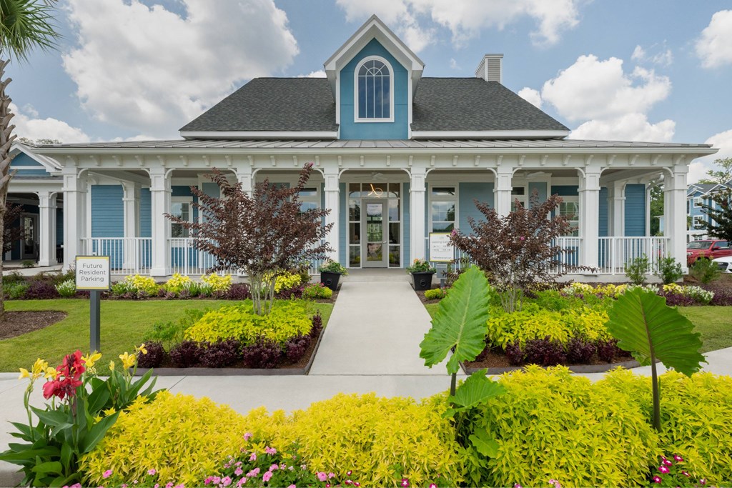 A blue and white house with a garden in front.