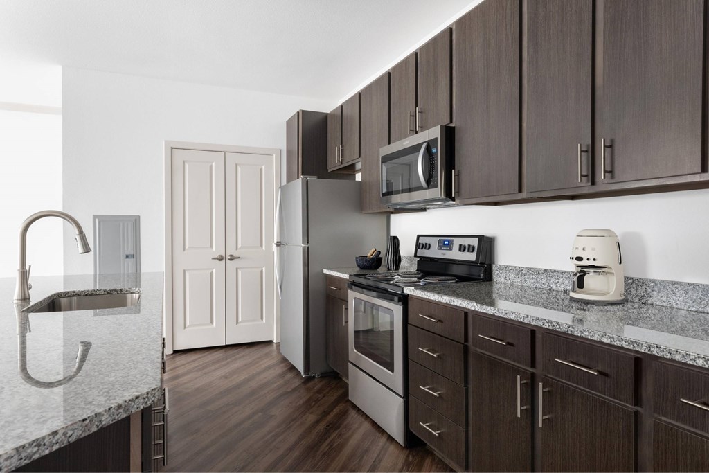A kitchen with brown cabinets and a white counter.