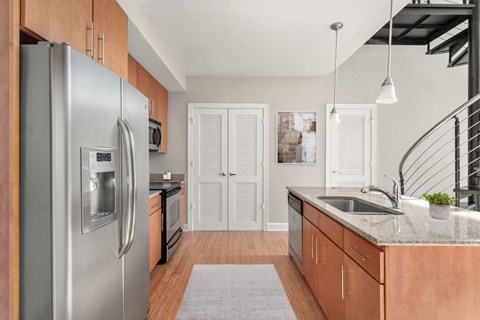 A modern kitchen with a stainless steel refrigerator and wooden cabinets.