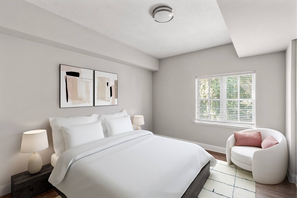 A bedroom with a bed, a chair, and a painting on the wall.