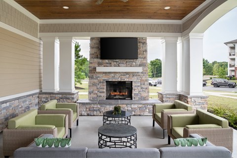 A patio with a fireplace and chairs.