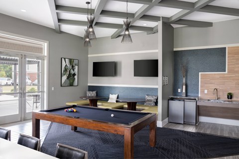 A room with a pool table and a television.