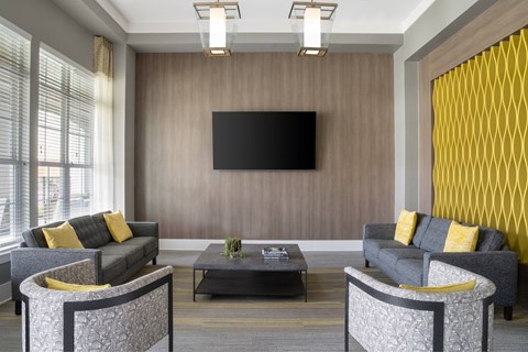 A modern living room with grey sofas and a black television.