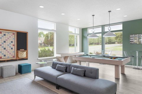 A living room with a pool table and a couch.