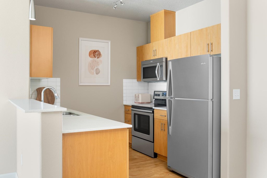A modern kitchen with wooden cabinets and stainless steel appliances.