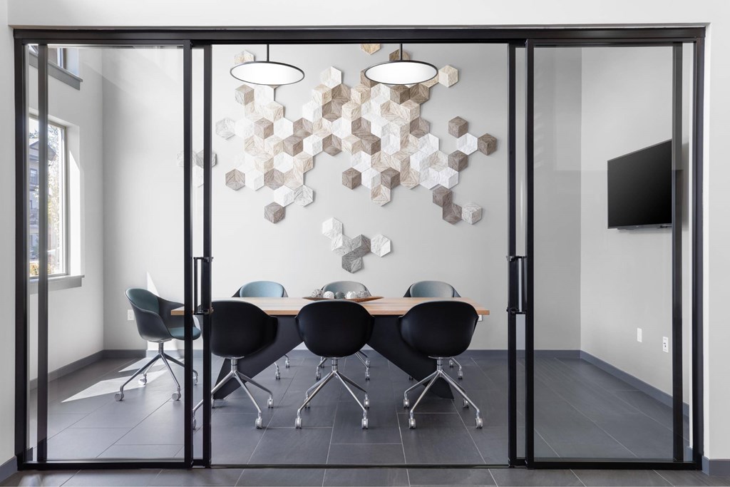 A conference room with a glass table and chairs.