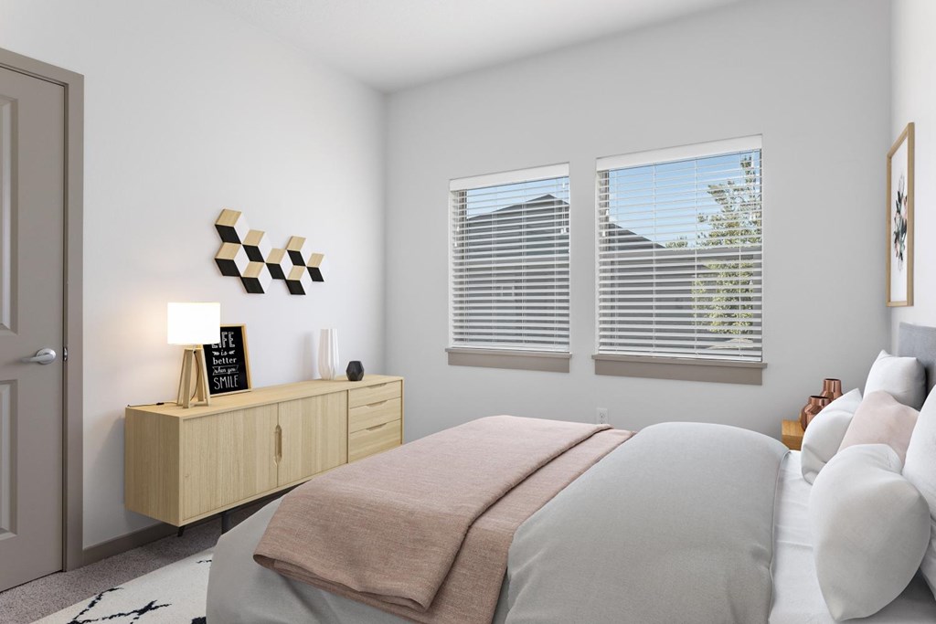 A bedroom with a bed, a nightstand with a lamp, and a wall art.
