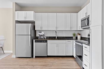 A modern kitchen with a refrigerator, dishwasher, and stove.