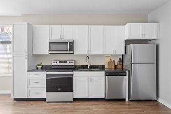 A modern kitchen with white cabinets and stainless steel appliances.