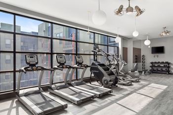 A gym with treadmills, elliptical machines, and other exercise equipment.