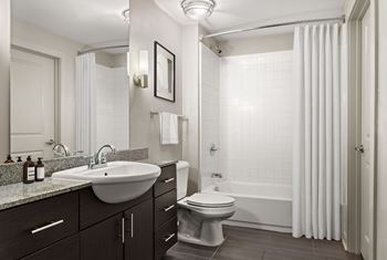 A bathroom with a white sink, toilet, and bathtub.