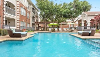 A large swimming pool surrounded by lounge chairs and umbrellas.