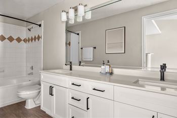 A bathroom with a white toilet, sink, and bathtub.
