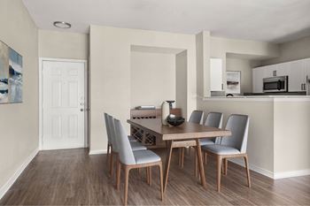 A dining room with a wooden table and grey chairs.