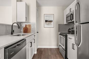 A modern kitchen with stainless steel appliances and white cabinets.