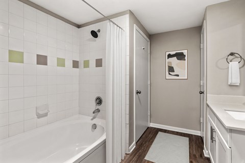 A white bathroom with a white tub and a white sink.