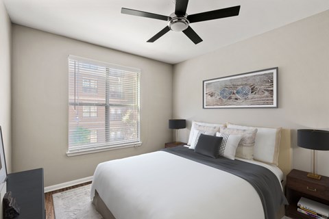 A bedroom with a bed, a ceiling fan, and a window with blinds.