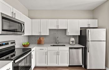 A modern kitchen with white cabinets and appliances.