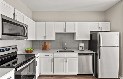 A modern kitchen with white cabinets and appliances.