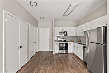 A kitchen with white cabinets and stainless steel appliances.