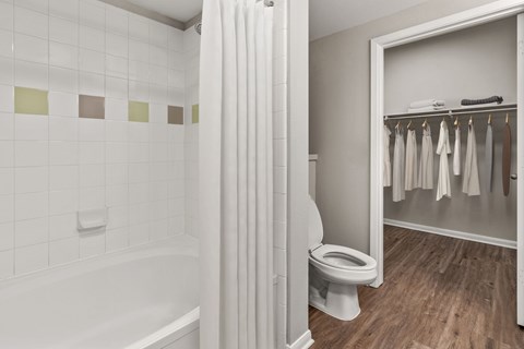 A white bathroom with a toilet and a bathtub.