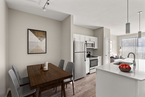 A modern kitchen with a wooden dining table and grey chairs.