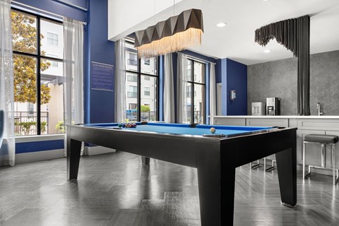 A pool table in a room with a blue wall.
