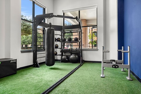 A gym with a green carpet and a punching bag.