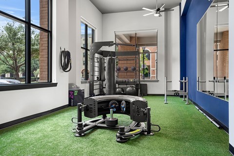A gym with a green carpet and a rowing machine.