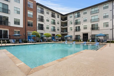 A large swimming pool surrounded by apartment buildings.