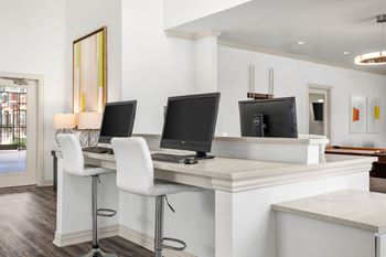 A white desk with two monitors and a laptop.
