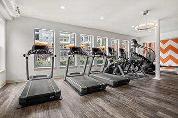 A gym with treadmills and elliptical machines.