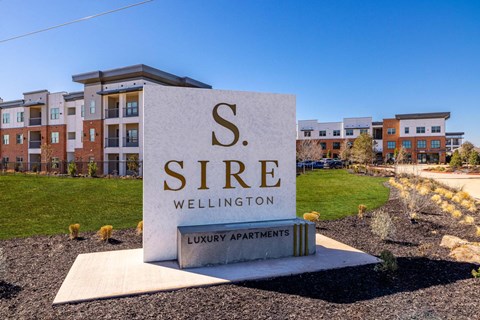 A sign for S. Sire Wellington luxury apartments is in the foreground.