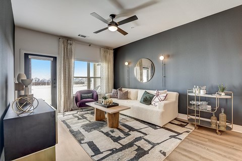 A living room with a white couch, a coffee table, and a ceiling fan.