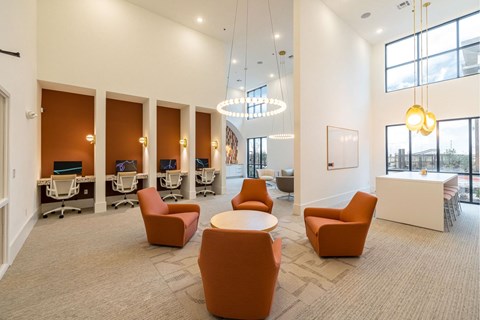 A modern office space with orange chairs and a white reception desk.
