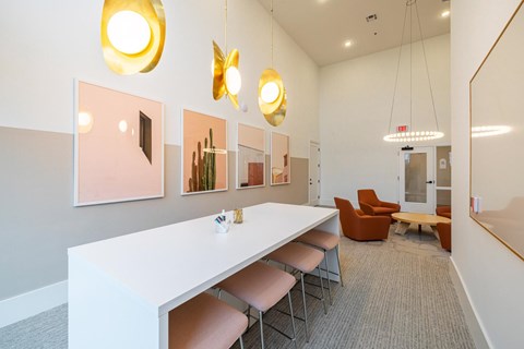 A conference room with a long white table and orange chairs.